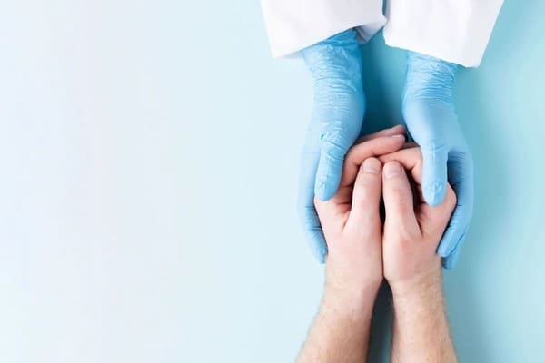 lekarz swoimi rękoma obejmuje ręcę pacjenta